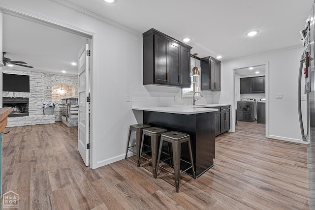 608 Finch Ave, Monette, AR 72447 - kitchen with ceiling fan, crown molding, light countertops, a fireplace, and light wood-type flooring