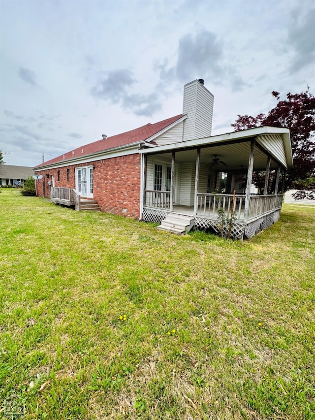 2208 John Cir, Newport, AR 72112 - back of property with a yard, a ceiling fan, brick siding, and a chimney