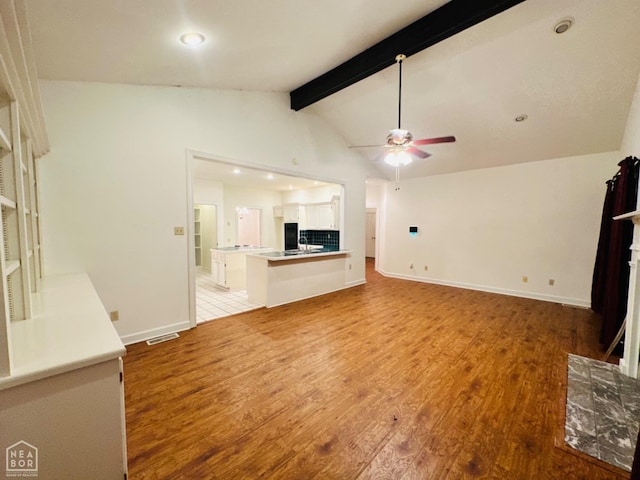 2208 John Cir, Newport, AR 72112 - unfurnished living room featuring vaulted ceiling with beams, light wood finished floors, visible vents, and a ceiling fan