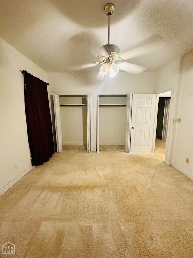 2208 John Cir, Newport, AR 72112 - unfurnished bedroom with two closets, baseboards, light carpet, and a textured ceiling