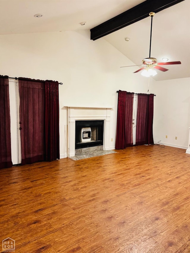 2208 John Cir, Newport, AR 72112 - unfurnished living room featuring a fireplace with flush hearth, a ceiling fan, wood finished floors, vaulted ceiling with beams, and baseboards