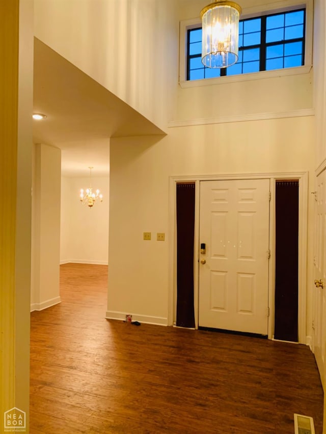 2208 John Cir, Newport, AR 72112 - entrance foyer with an inviting chandelier, visible vents, a high ceiling, dark wood-style flooring, and baseboards