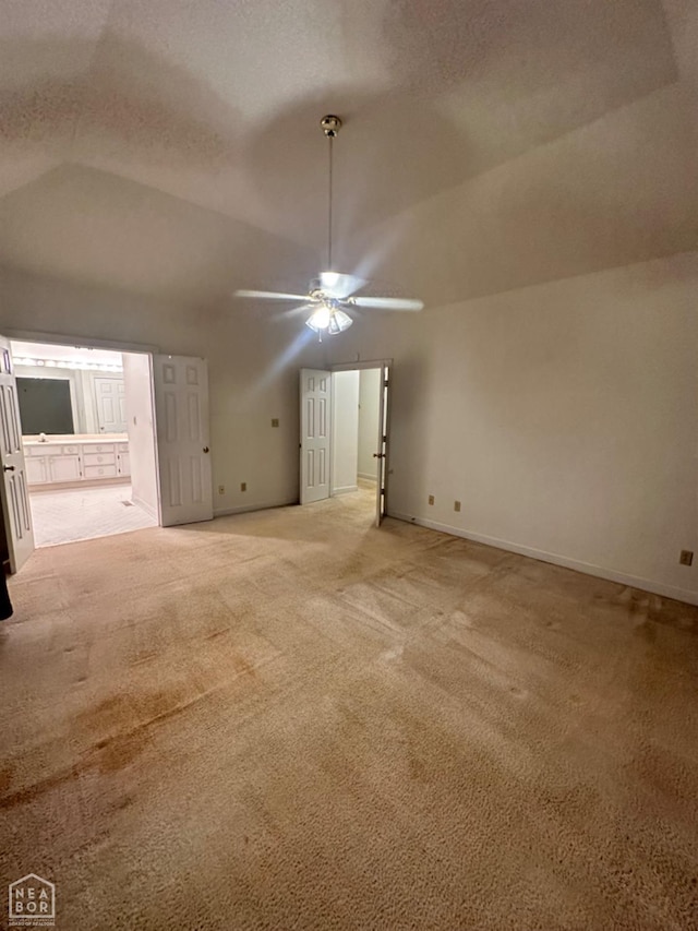 2208 John Cir, Newport, AR 72112 - interior space featuring lofted ceiling, baseboards, ensuite bathroom, ceiling fan, and light colored carpet