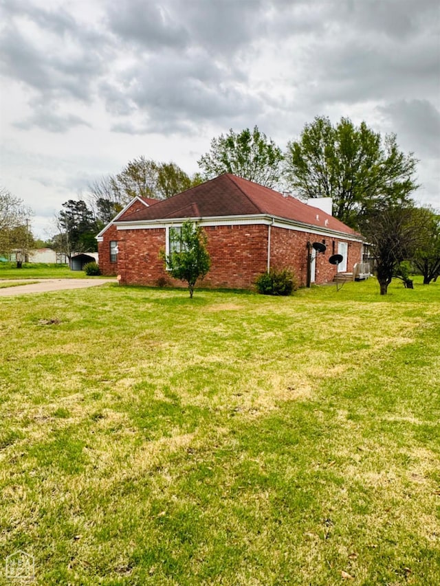 2208 John Cir, Newport, AR 72112 - view of side of home featuring brick siding, driveway, and a lawn