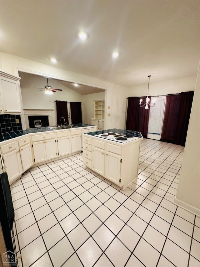 2208 John Cir, Newport, AR 72112 - kitchen with a fireplace, open floor plan, white cabinets, tile countertops, and ceiling fan with notable chandelier