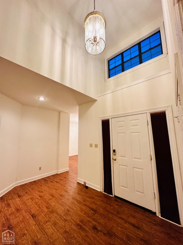 2208 John Cir, Newport, AR 72112 - foyer entrance featuring dark wood-style flooring, a towering ceiling, baseboards, and a notable chandelier
