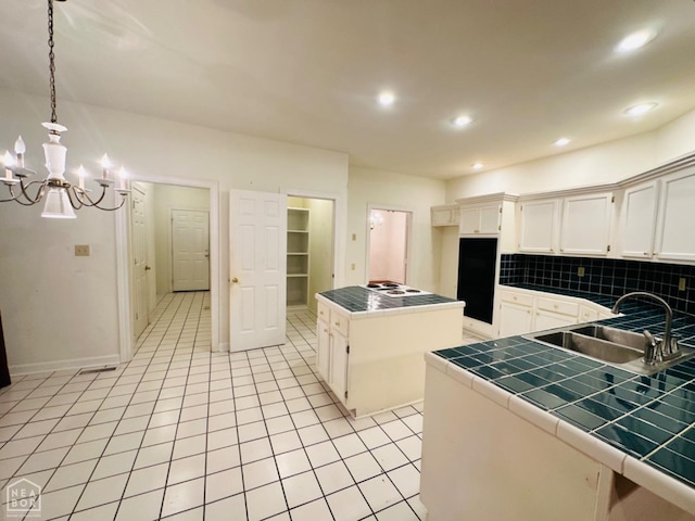 2208 John Cir, Newport, AR 72112 - kitchen with tile countertops, light tile patterned floors, a sink, a notable chandelier, and backsplash