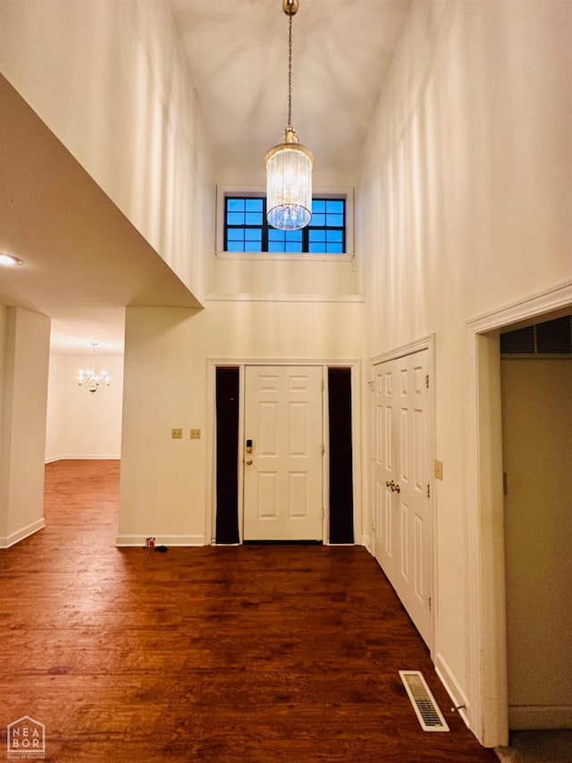 2208 John Cir, Newport, AR 72112 - entryway with visible vents, a chandelier, a high ceiling, wood finished floors, and baseboards