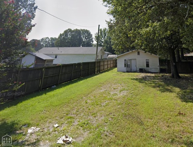 view of yard featuring an outdoor structure and fence