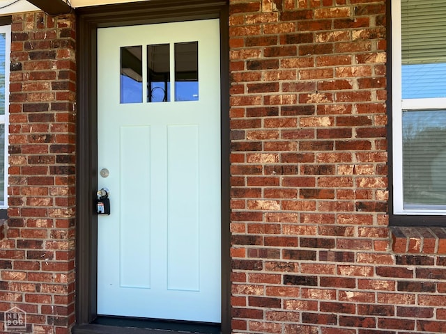 doorway to property featuring brick siding