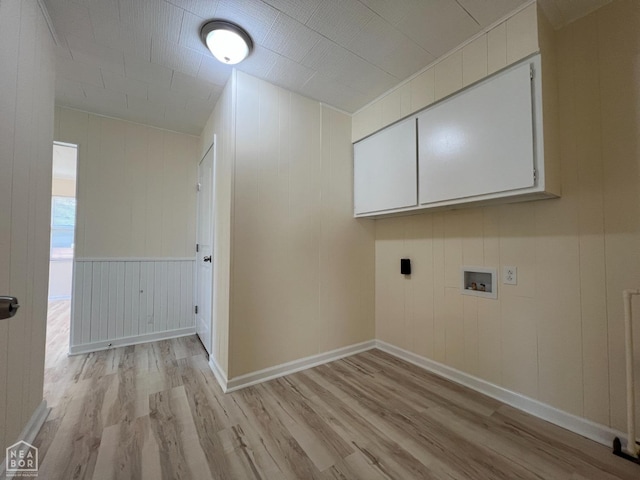 washroom with cabinet space, light wood-style flooring, hookup for a washing machine, and baseboards