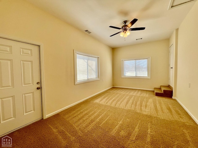 spare room with visible vents, baseboards, a ceiling fan, and carpet flooring