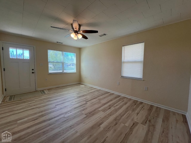 foyer entrance featuring light wood finished floors, visible vents, baseboards, and ceiling fan