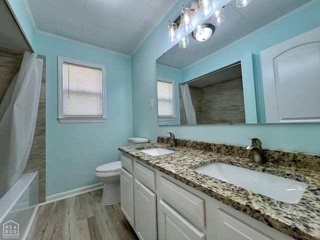 full bathroom featuring toilet, crown molding, wood finished floors, and a sink