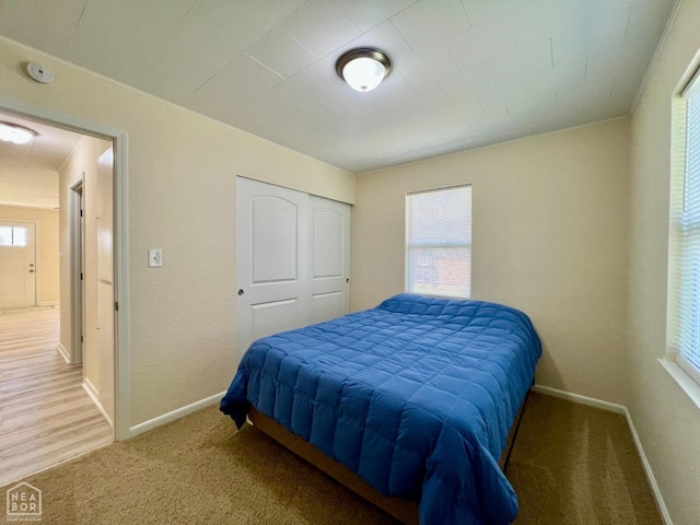 bedroom with baseboards, multiple windows, and carpet flooring