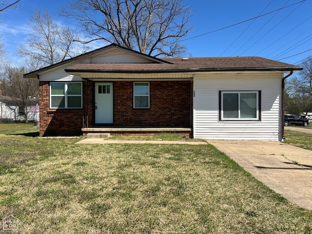 view of front of property featuring roof with shingles, a porch, brick siding, and a front lawn