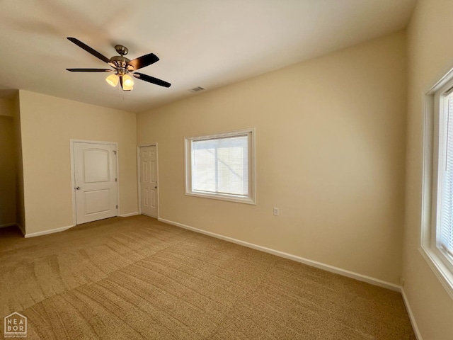 spare room with carpet floors, baseboards, and plenty of natural light