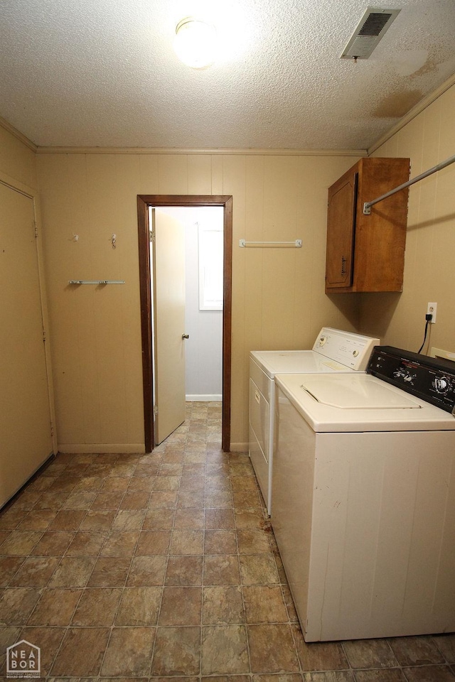1704 Rector Rd, Paragould, AR 72450 - laundry area with cabinet space, washer and clothes dryer, and a textured ceiling