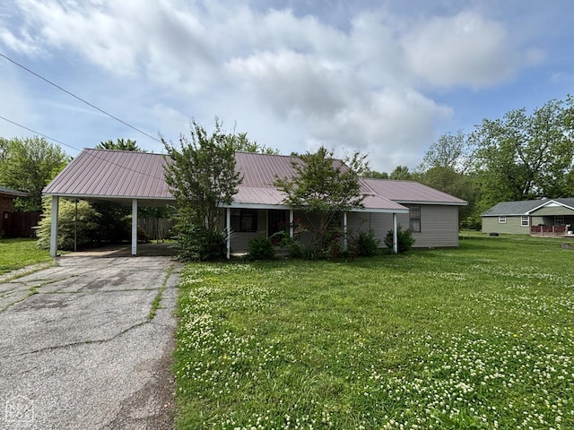 ranch-style home featuring a carport, metal roof, a front yard, and aphalt driveway