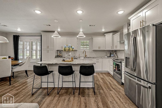 4328 Lynx Ln, Jonesboro, AR 72405 - kitchen featuring stainless steel appliances, white cabinets, light stone counters, dark wood-style floors, and a breakfast bar area