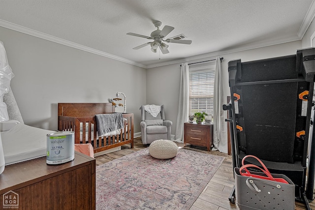 5010 S 28th St, Paragould, AR 72450 - bedroom featuring a crib, ornamental molding, wood finished floors, a textured ceiling, and a ceiling fan