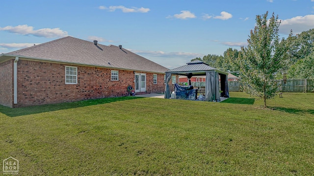 5010 S 28th St, Paragould, AR 72450 - rear view of house featuring a gazebo, a patio, brick siding, a fenced backyard, and roof with shingles