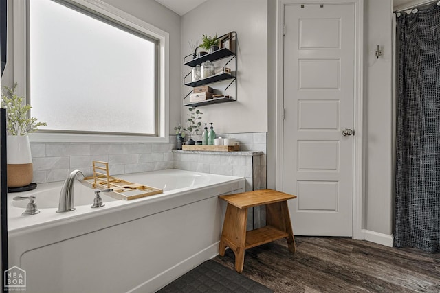1003 Ava Ln, Paragould, AR 72450 - bathroom featuring wood finished floors and a bath