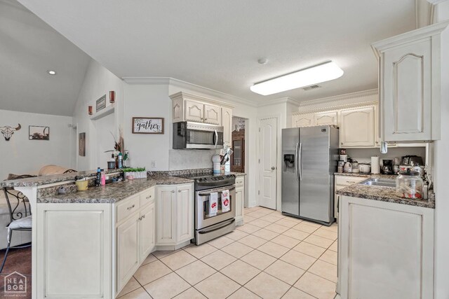 430 County Road 751, Jonesboro, AR 72405 - kitchen with stainless steel appliances, a peninsula, light tile patterned floors, dark stone counters, and a kitchen bar