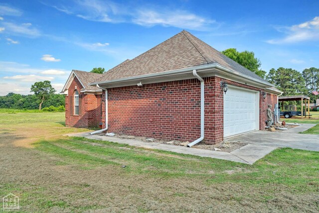 430 County Road 751, Jonesboro, AR 72405 - view of side of home featuring an attached garage, brick siding, a yard, and roof with shingles