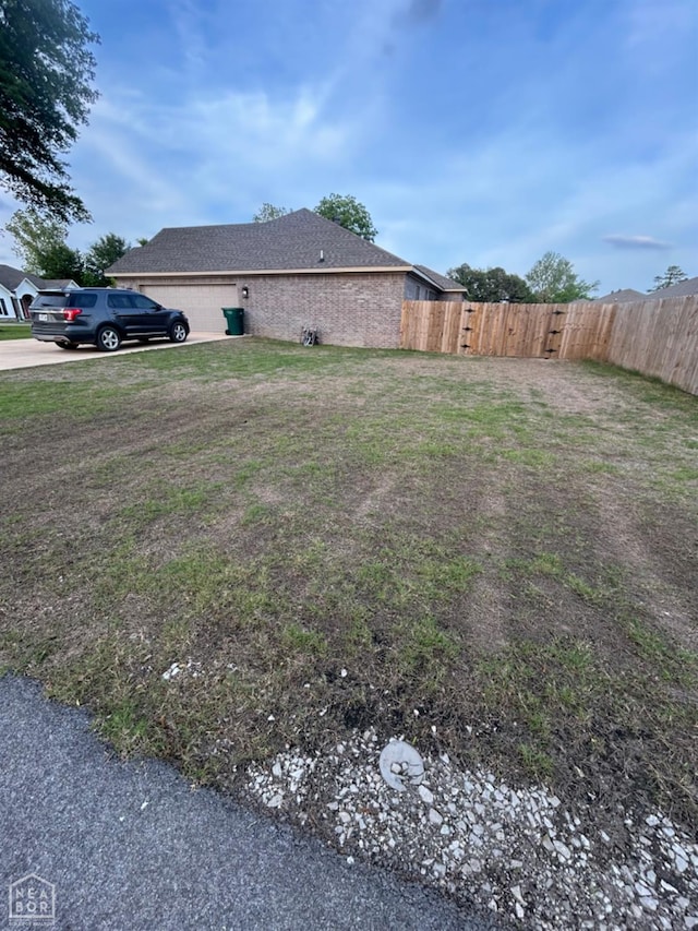 view of yard featuring fence and driveway