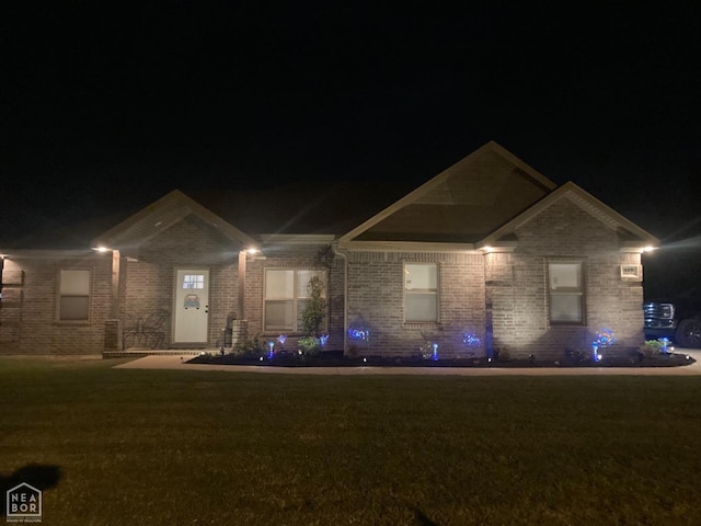 ranch-style home with brick siding and a yard