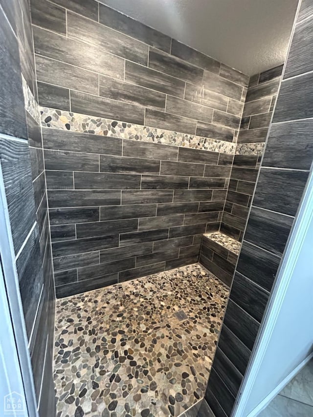 full bath featuring a tile shower