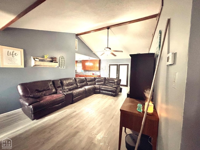 living room featuring a ceiling fan, light wood finished floors, and lofted ceiling with beams