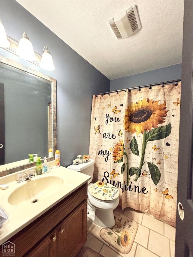 bathroom featuring vanity, toilet, a textured ceiling, and visible vents