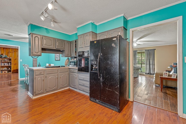 406 E Ash St E, Keiser, AR 72351 - kitchen featuring black appliances, gray cabinetry, a textured ceiling, a ceiling fan, and wood finished floors