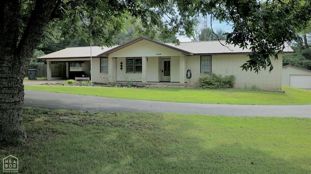 5206 Johnwood Dr, Jonesboro, AR 72404 - ranch-style home featuring a front yard, an outdoor structure, brick siding, and metal roof