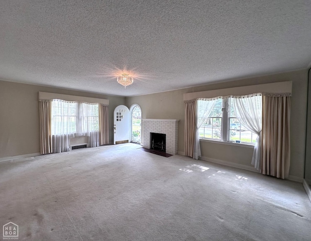 582 N 4th Ave, Piggott, AR 72454 - unfurnished living room with a fireplace, a textured ceiling, carpet, and baseboards