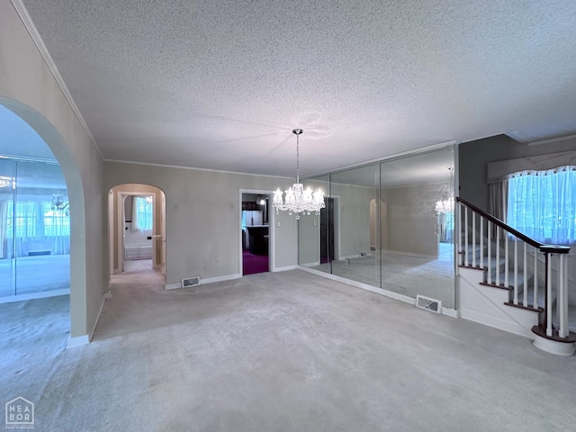 582 N 4th Ave, Piggott, AR 72454 - unfurnished dining area featuring a chandelier, a textured ceiling, arched walkways, crown molding, and baseboards