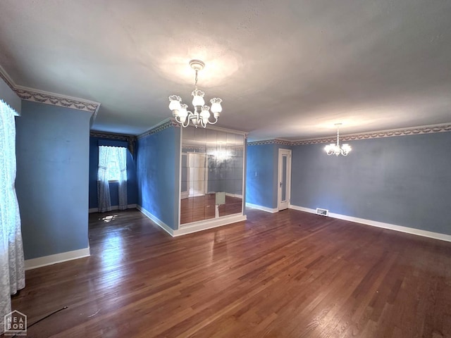 582 N 4th Ave, Piggott, AR 72454 - spare room featuring a chandelier, dark wood-type flooring, ornamental molding, and baseboards