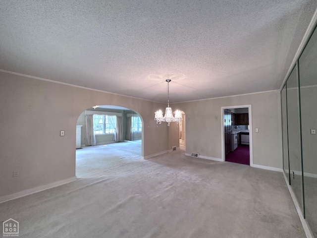 582 N 4th Ave, Piggott, AR 72454 - unfurnished dining area featuring a textured ceiling, arched walkways, a chandelier, carpet flooring, and ornamental molding