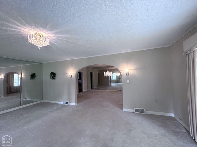 582 N 4th Ave, Piggott, AR 72454 - empty room featuring a chandelier, arched walkways, a textured ceiling, ornamental molding, and baseboards
