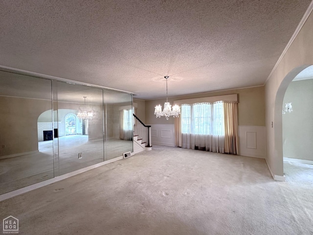 582 N 4th Ave, Piggott, AR 72454 - unfurnished dining area with a chandelier, arched walkways, a textured ceiling, healthy amount of natural light, and wainscoting