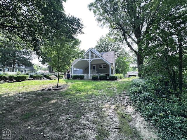 582 N 4th Ave, Piggott, AR 72454 - rear view of house with covered porch and a lawn