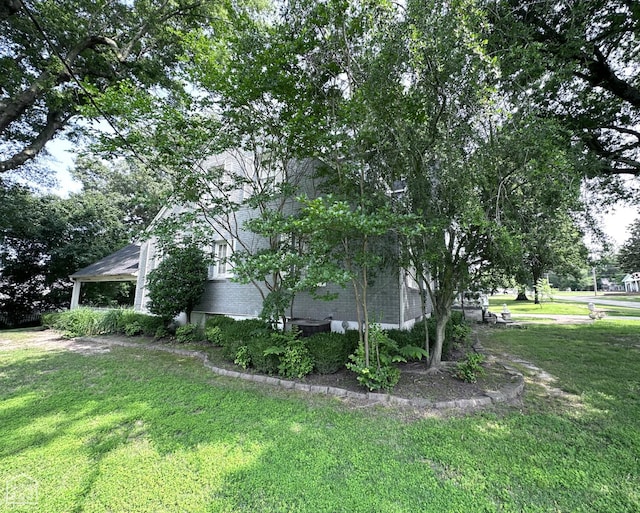 582 N 4th Ave, Piggott, AR 72454 - view of home's exterior with a lawn and brick siding