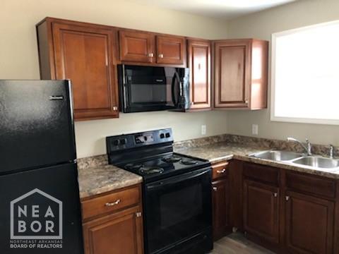 1805 Covey Dr, Jonesboro, AR 72404 - kitchen with black appliances, brown cabinets, and light countertops