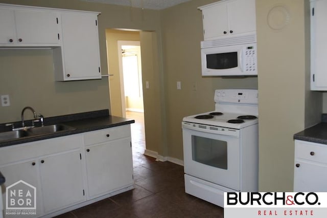 1805 Covey Dr, Jonesboro, AR 72404 - kitchen with white appliances, dark countertops, and white cabinetry