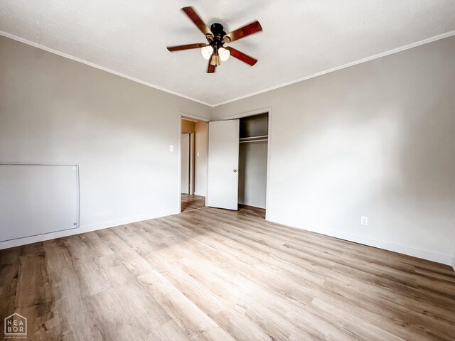 unfurnished bedroom with a closet, baseboards, ornamental molding, a ceiling fan, and wood finished floors