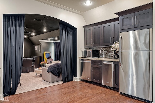 kitchen with visible vents, open floor plan, wood finished floors, backsplash, and stainless steel appliances