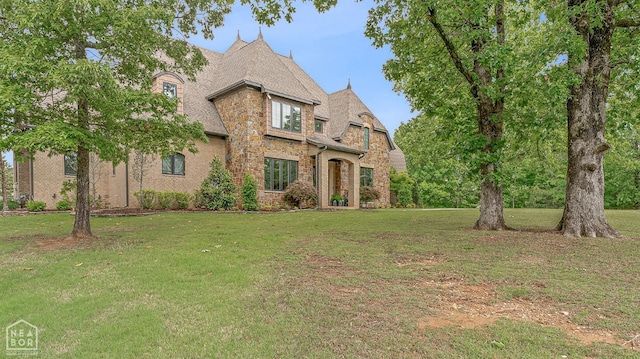 view of front of property with a front lawn, brick siding, and stone siding