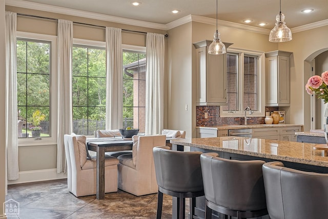 kitchen featuring ornamental molding, light stone counters, recessed lighting, decorative backsplash, and hanging light fixtures